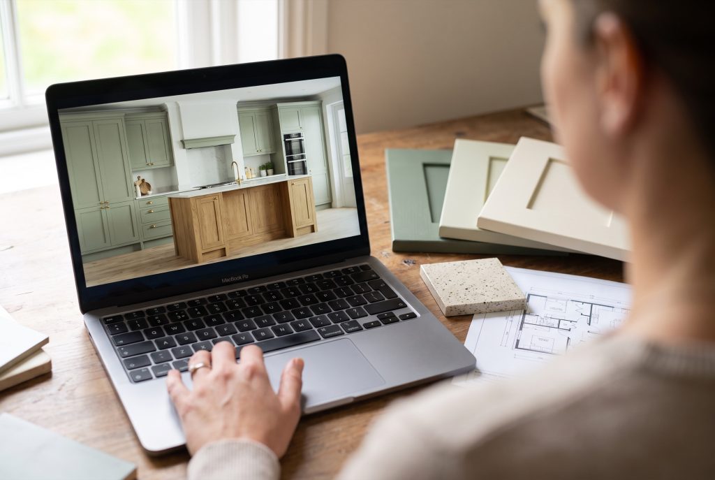 3D kitchen design shown on a laptop beside plans and samples